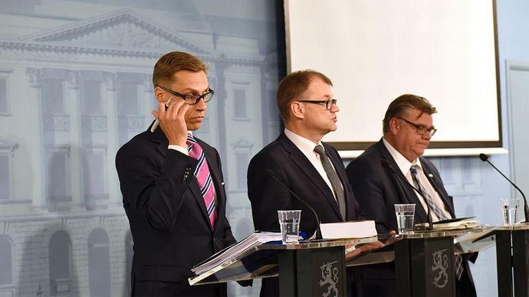 Hallituspuolueiden johtajat rivissä.