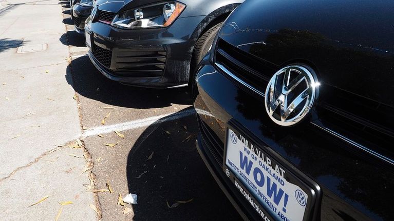 Autoja Volkswagen-myymälän pihassa. Rekisterikilven mainoksessa lukee, että Volkswagenissa on jotakin erilaista. 