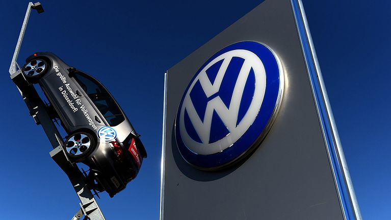 Volkswagenin auto ja isokokoinen logo ovat Volkswagenin konttorin edustalla Düsseldorfissa.
