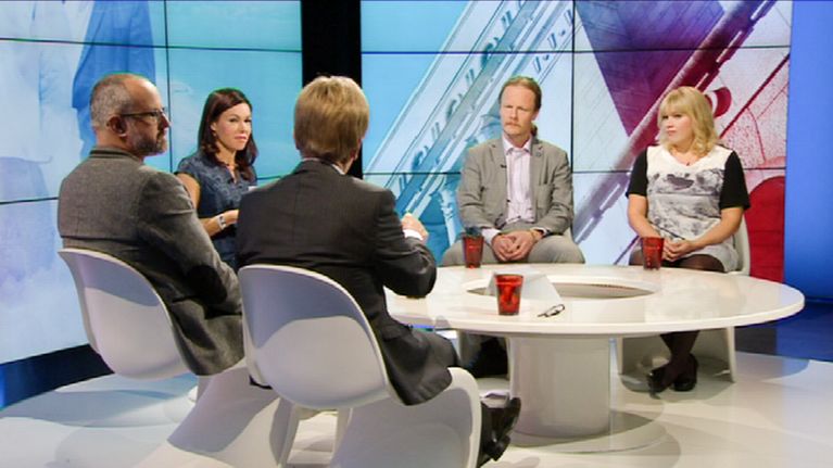 keskustelijat istuvat studiossa