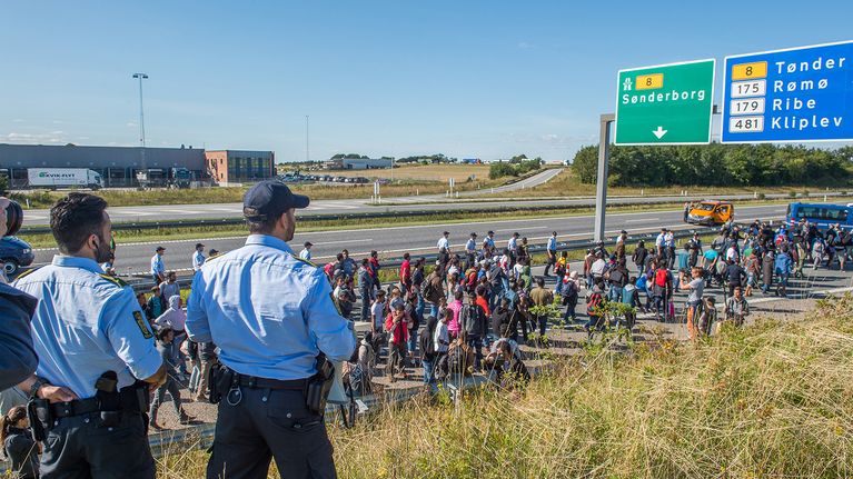 Poliisit katselivat ,kuinka pääasiassa Syyriasta ja Irakista tulleet turvapaikanhakijat aikoivat kävellä Tanskasta Ruotsiin 9. syyskuuta.