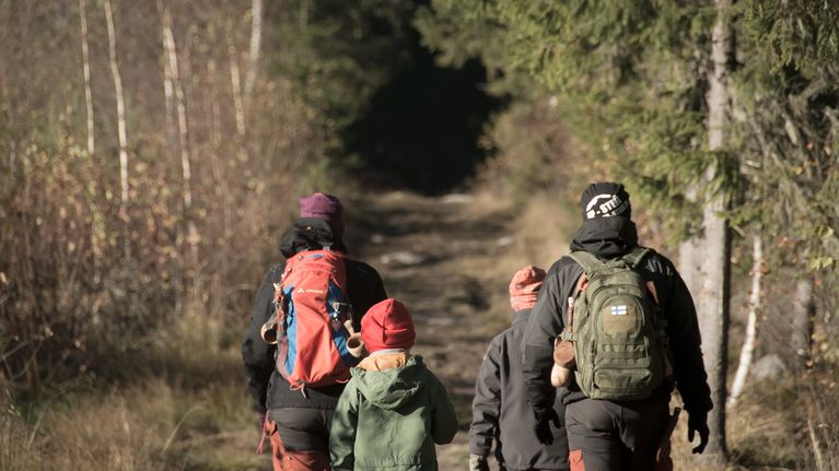 Isä ja äiti kahden poikansa kanssa päiväretkellä Perhonjoen retkeilureitillä. 