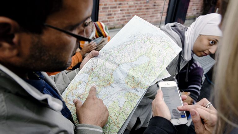 Ruotsiin saapuneet turvapaikanhakijat tutkivat karttaa Malmön rautatieasemalla.