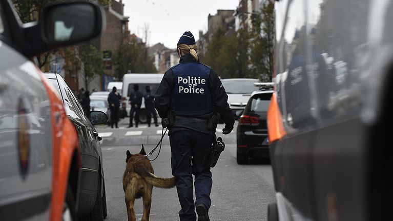 Belgian poliisivoimilla oli suuroperaatio Molenbeekin lähiössä Brysselissä maanantaina 16. marraskuuta. Naispoliisi kävelyllä koiran kanssa kadulla.