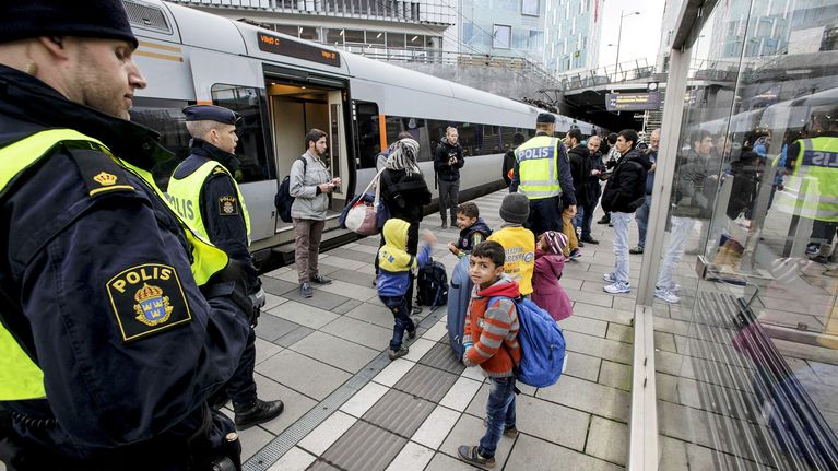 Poliiseja ja turvapaikanhakijoita Malmön asemalla 12. marraskuuta.