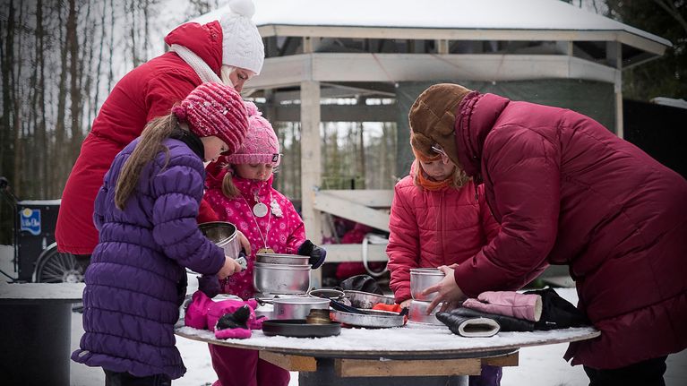 Kokkolan luontokoulun iltapäiväkerholaiset kokoavat ulkona trangioita.