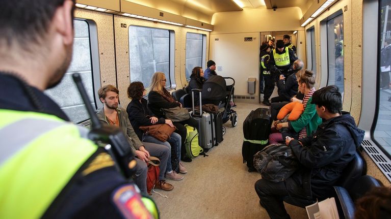 Poliisi tarkasti matkustajien henkilöllisyystodistuksia Tanskan ja Ruotsin välisessä junassa 12. marraskuuta 2015.