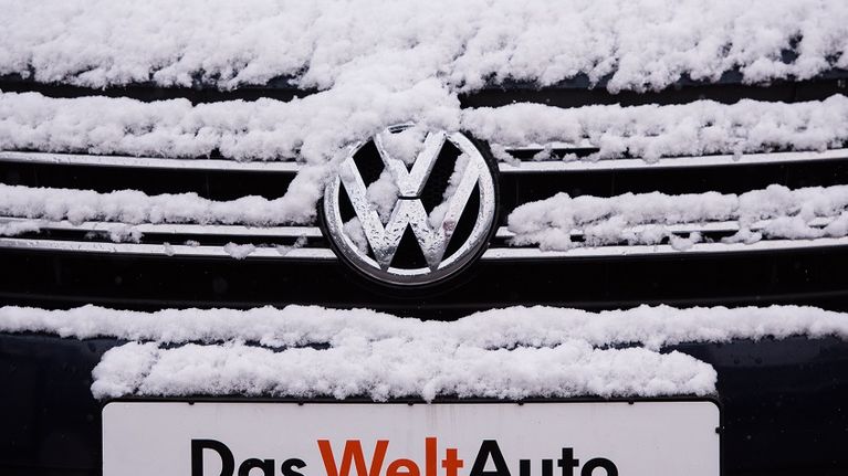 Volkwagenin keula lumen peitossa. Rekisterikilvessä lukee saksaksi "maailmanauto". 