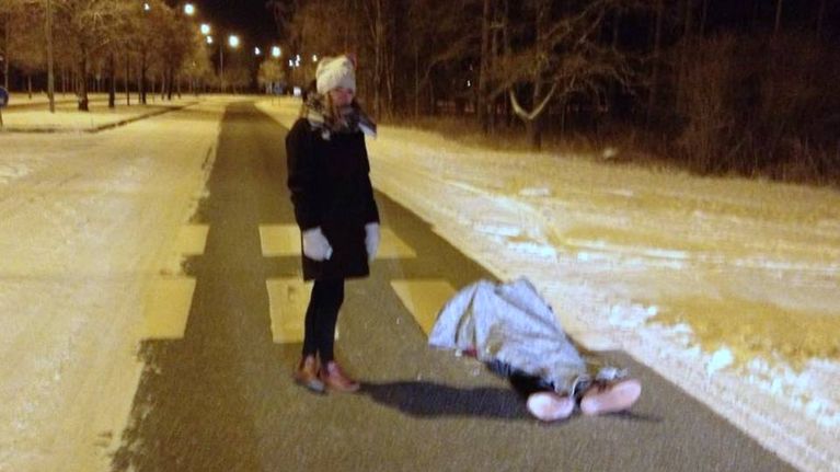 Nuorin nainen seisoon viltillä peitetyn miehen vierellä 