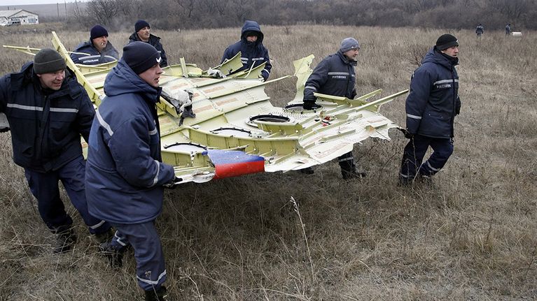 Pelastushenkilöstö kantoi MH17-koneen osia Grabovon kylän lähellä Ukrainassa 18. marraskuuta 2014. 