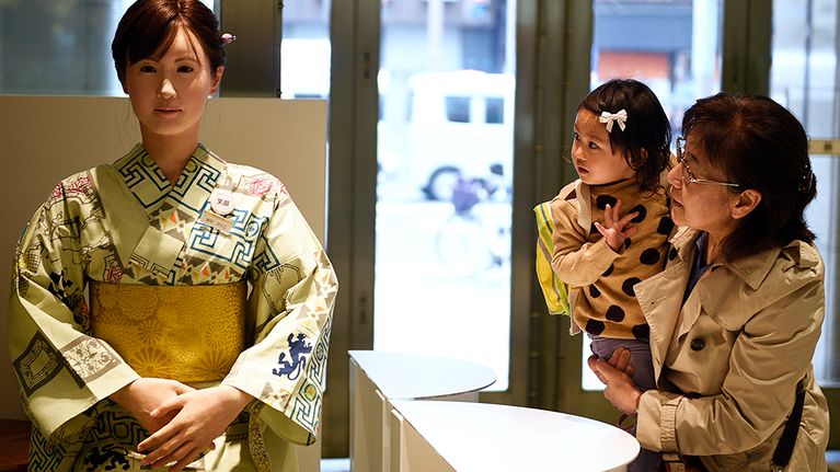 Äiti ja lapsi katselevat Toshiban valmistamaa AIko Chihira -nimistä humanoidirobottia, joka toivotti asiakkaita tervetulleiksi Nihonbashi Mitsukoshi -tavarataloon Tokiossa.
