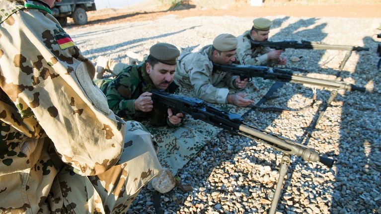 kurdisotilaita makuulla konekiväärien kanssa