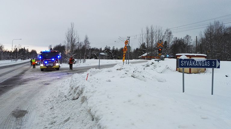 Hälytysajoneuvo seisoo tien risteyksessä lähellä onnettomuuspaikkaa.