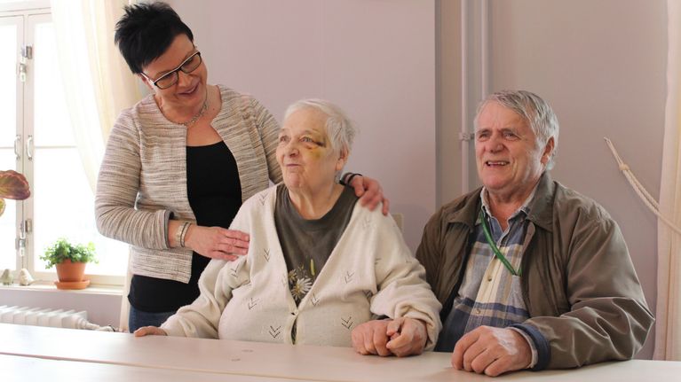 Senioripäiväkoti Varpusen yrittäjä Mari Kotilainen asiakkaansa Anjan ja hänen omaishoitajansa Simo Angelin kanssa.