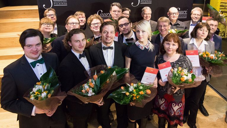 ryhmä ehdokkaita kukkapuskat kädessä
