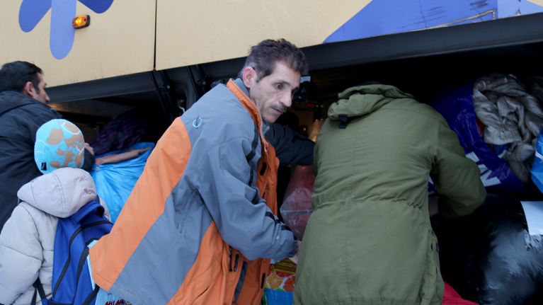 Orimattilaan lähtevät turvapaikanhakijat pakkaavat tavaroitaan bussiin Vuorannan vastaanottokeskuksessa.