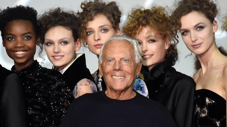 Muotisuunnittelija Giorgio Armani valokuvamallien ympäröimänä.