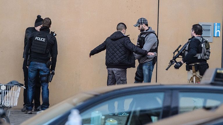 Poliisit tarkastavat jalankulkijoita kadulla.