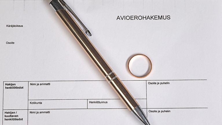 Avioerohakemus, vihkisormus ja kynä.