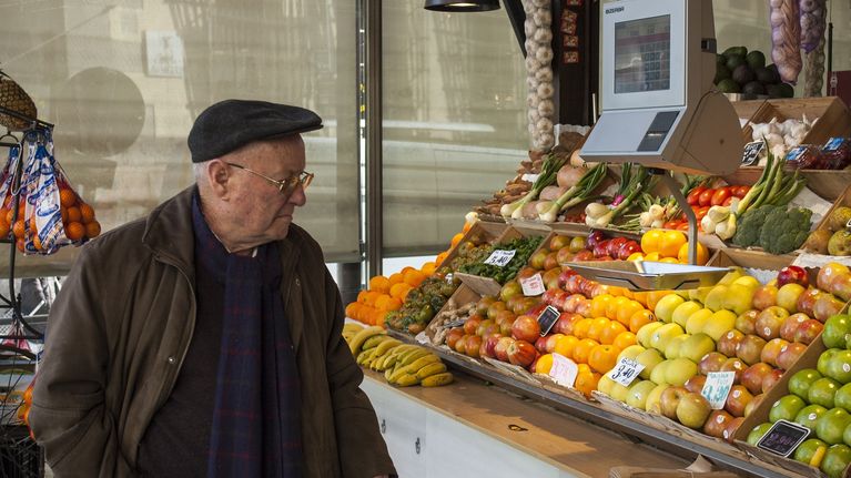 Mies katselee hedelmiä myyntikojussa. Espanjassa on päästy eroon pahimmasta talouskriisistä.