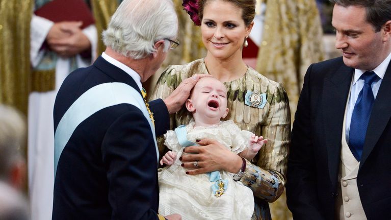 Kaarle Kustaa silittää kolmannen lapsenlapsensa prinssi Nicolasin päätä kastetilaisuudessa. 