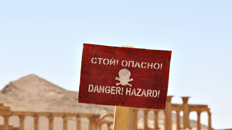 Varoituskyltti hengenvaarasta. Isis-järjestö jätti vetäytyessään räjähteitä Palmyran rauniokaupunkiin. Venäläiset sotilaat ovat raivanneet alueelta miinoja.