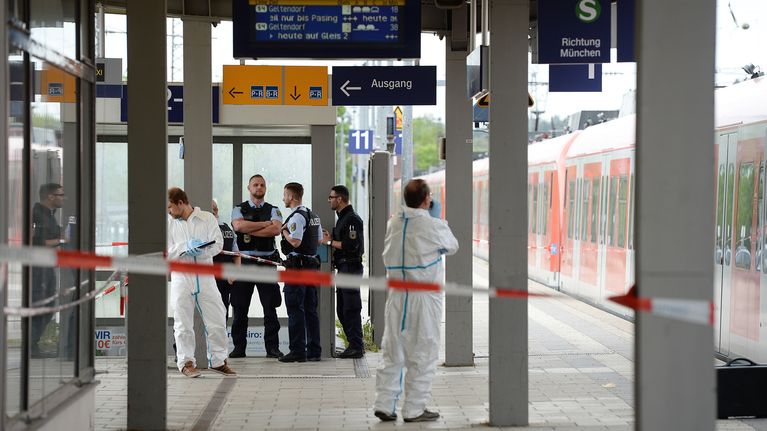 Poliiseja ja rikospaikan tutkijoita Grafingin juna-asemalla Saksassa 10. toukokuuta.