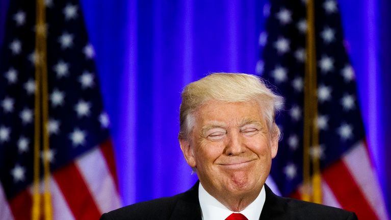 Trump hymyilee silmät kiinni.