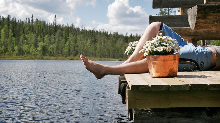 Mies makaa laiturilla.