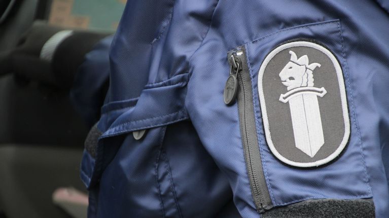 Poliisin logo poliisimiehen hihassa.