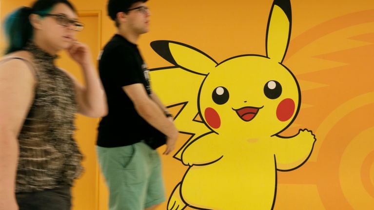 Turistit kävelevät seinään maalatun Pikachu-hahmon ohi Japanissa heinäkuussa 2016. 