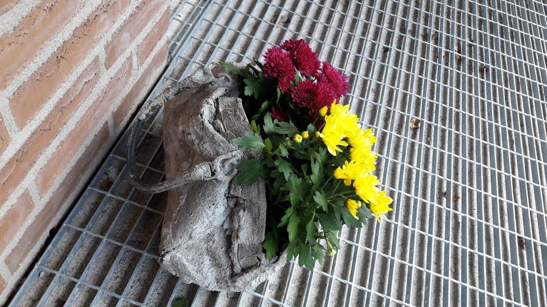 Kynnystien palvelukodin ovella betonoitu laukku.