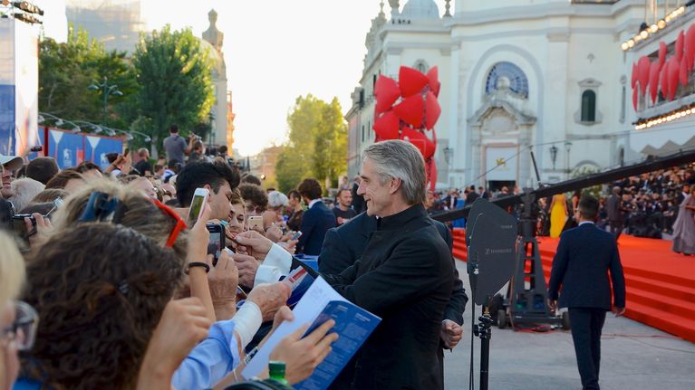 Brittinäyttelijä Jeremy Irons jakaa nimikirjoituksia faneilleen.