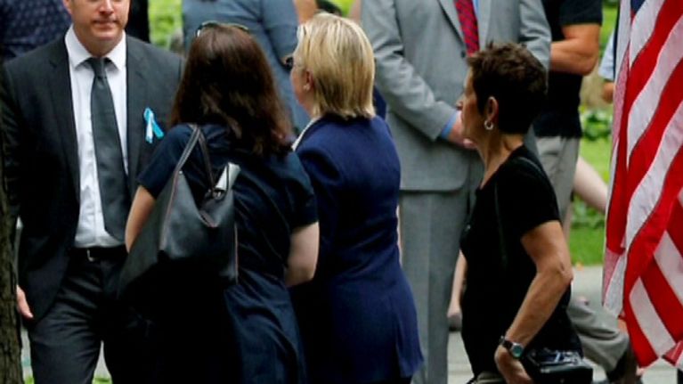 Hillary Clinton kävelee pois WTC-tilaisuudesta avustajiensa ympäröimänä. 