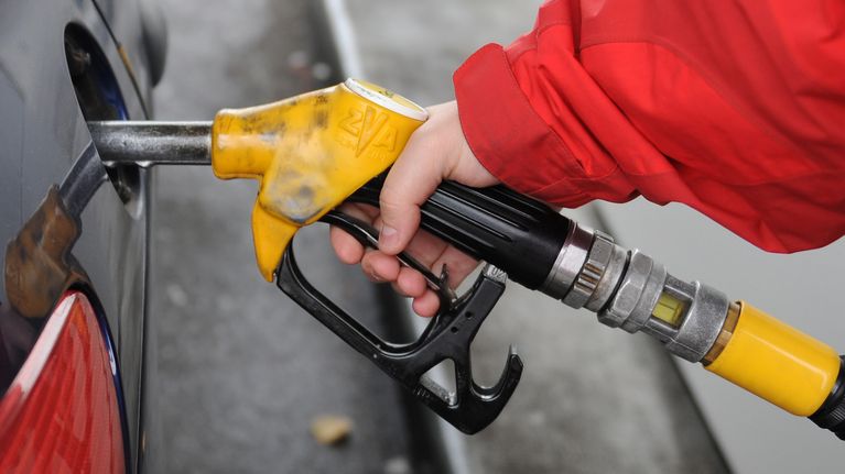 Henkilö tankkaa autoa.