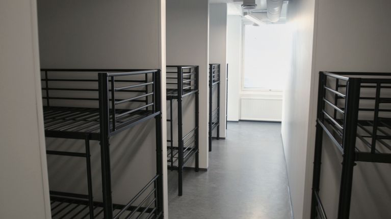 Patjattomia kerrossänkyjä muuten tyhjässä huoneessa.