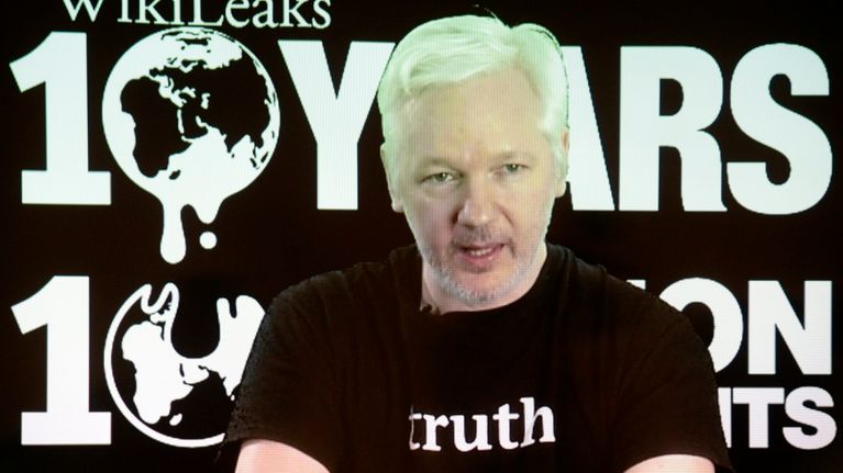 Vaaleahiuksinen mies mustassa t-paidassa, jossa lukee englanniksi totuus. Taustalla teksti Wikileaks 10 years.