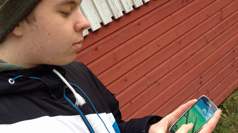 poika puhelin kädessä