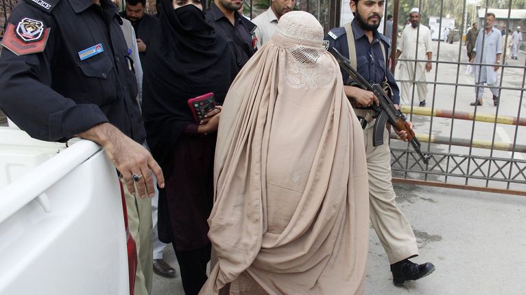 Poliisit saattelevat Sharbat Gulaa Peshawarissa, Pakistanissa, 4. marraskuuta.