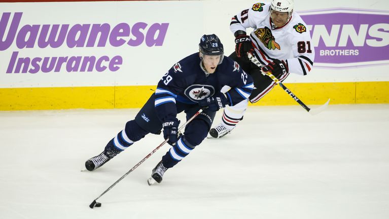 Patrik Laine kiekon kanssa ottelussa Chicagoa vastaan. Taustalla Marian Hossa jahtaa suomalaistähteä.