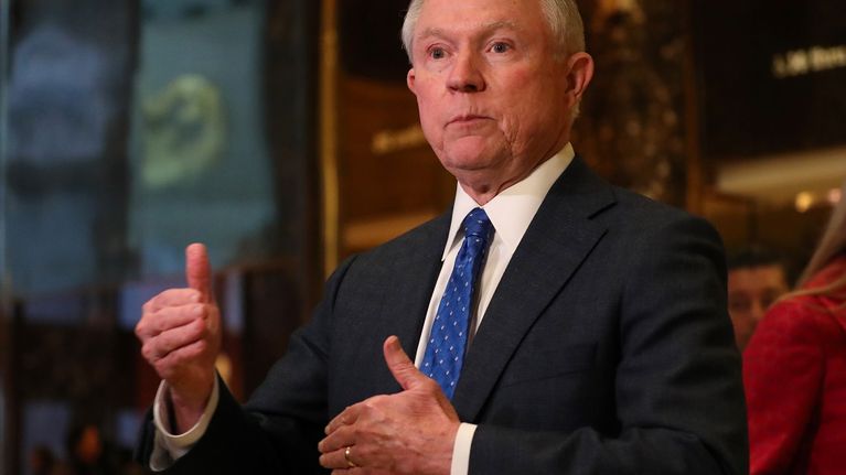 Jeff Sessions istuu tummassa puvussa, sininen kravatti kaulassaan. Hän on juuri selittämässä jotain päätellen käsien asennosta.
