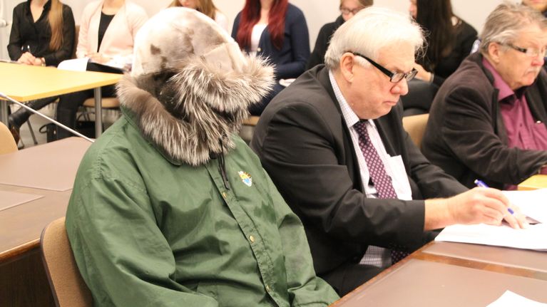 Vastaaja ja asianajaja oikeussalissa.