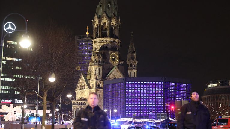 Poliiseja partioimassa lähellä turmapaikkaa Berliinissä 19. joulukuuta. Taustalla Keisari Vilhelmin muistokirkko. 