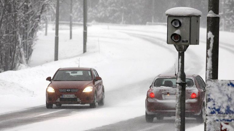 autoja tiellä talvella ja peltipoliisi