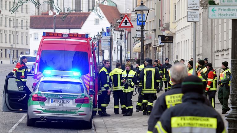 Poliisiauto, ambulanssi ja pelastustyöntekijöitä autiolla kadulla. 