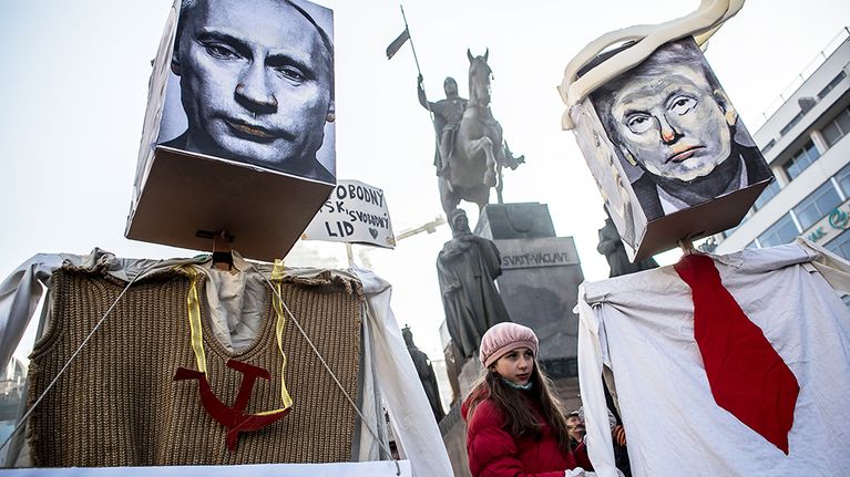 Mielenosoittajat kantavat Donald Tumpin ja Venäjän presidentin Vladimir Putinin kuvia Prahassa.