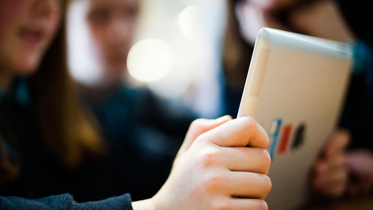 Lapset käyttävät tablettia.