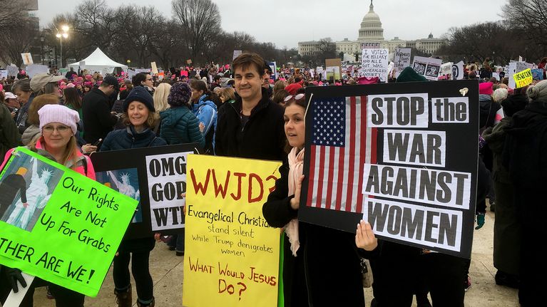 Ihmisiä isossa mielenosoittajajoukossa kyltteineen Capitolin edessä Washingtonissa. 