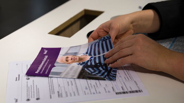 ihminen selailee toimeentulotukihakemuksen ohjeita