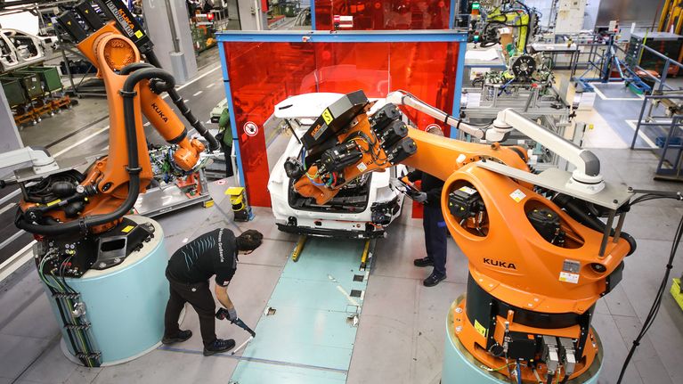 Robotit työskentelevät ihmisten kanssa saksalaisessa autotehtaassa.